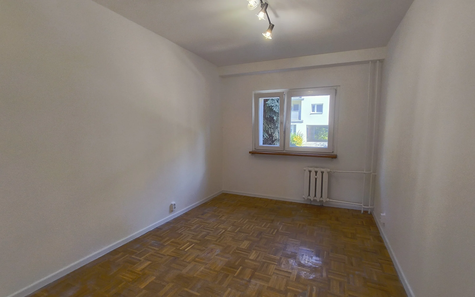 Pokój z drewnianą podłogą. Renowacja mieszkania we Wrocławiu